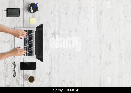 Moderne Laptop und Handy am Schreibtisch mit freiem Speicherplatz für Text. Weiße Holz Textur im Hintergrund. Stockfoto