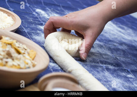 Herstellung von hausgemachten Käse Kuchen oder andere Art von Gebäck Vorspeise oder Süßigkeiten auf einer Tischdecke Stockfoto