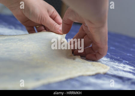 Erstellen von hausgemachten Phyllo oder Strudel Teig auf einer home Tischdecke für Käsekuchen oder andere Art von traditionellem Gebäck. Stockfoto