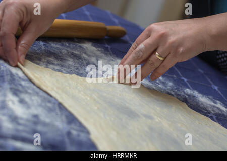 Erstellen von hausgemachten Phyllo oder Strudel Teig auf einer home Tischdecke für Käsekuchen oder andere Art von traditionellem Gebäck. Stockfoto