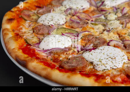 Nahaufnahme Foto von Pizza mit Wurst, Gewürzgurken, Zwiebeln und Meerrettich. Selektiven Fokus. Stockfoto