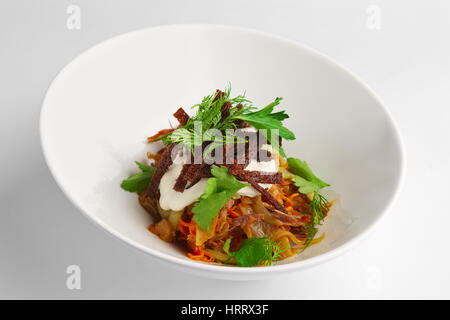 Tiefe Teller mit Salat mit Bohnen, Kohl und Gewürzgurken auf weißem Hintergrund Stockfoto