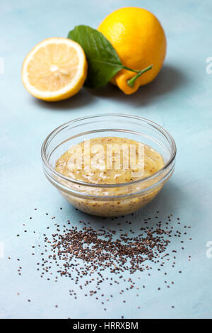 Lemon Curd Chia Pudding in eine Glasschüssel,, frischen Zitronen auf blauem Hintergrund Stockfoto