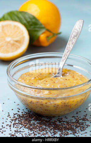 Lemon Curd Chia Pudding in eine Glasschüssel,, frischen Zitronen auf blauem Hintergrund Stockfoto