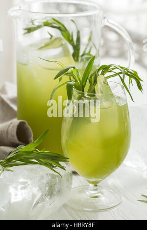 Hausgemachte kalte Limonade mit Estragon Estragon Blätter auf weißer Holztisch. Wite Hintergrund. Stockfoto