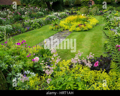 Chenies Manor versunkene Garten in seiner ganzen Schönheit. Zeigt den Zierteich, bevölkert Reich Staudenrabatten im Juni. Frische Blätter und pink.flora. Stockfoto