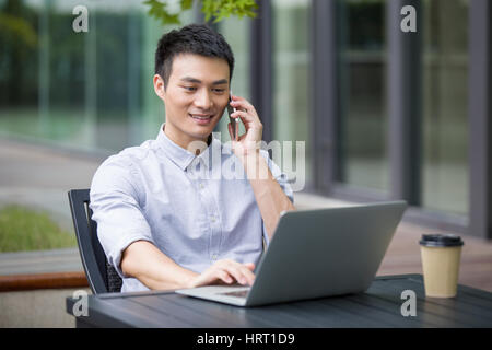 Junger Geschäftsmann reden über Handy im Straßencafé Stockfoto