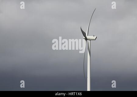 Windturbine gegen bewölktem Himmel Stockfoto