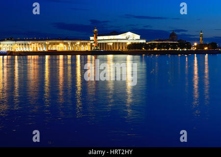 Panoramablick auf der Nehrung von Vasilievsky Insel, Rostral Spalten und das Schifffahrtsmuseum mit der Reflexion von Licht in die Newa spät während der Stockfoto