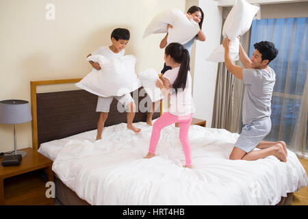 Junge Familie mit Kissenschlacht Stockfoto