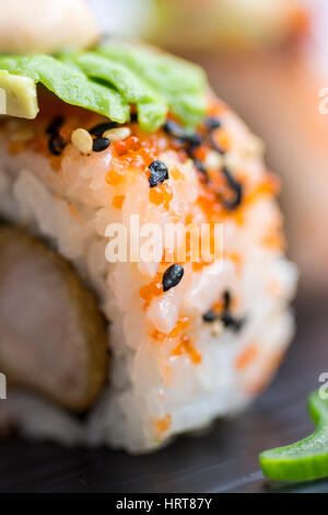 Auf dunkle Steinplatte serviert frische Sushi-Rollen. Sushi Set mit Hummer, Avocado, Kaviar und schwarzem Sesam. Traditionelle japanische Küche. Stockfoto