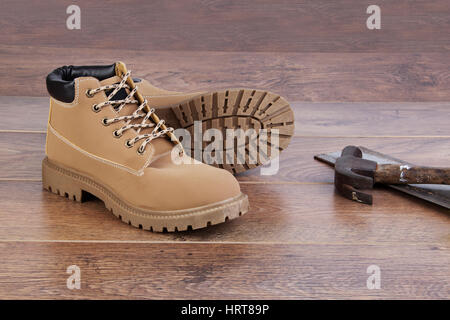 Arbeitsstiefel auf Holzboden mit Werkzeugen Stockfoto