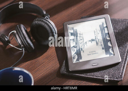 Paar Kopfhörer und open Ebook-Reader auf dem Schreibtisch Stockfoto