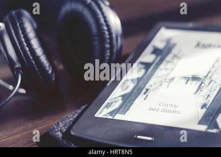 Paar Kopfhörer und open Ebook-Reader auf dem Schreibtisch Stockfoto