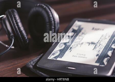 Paar Kopfhörer und open Ebook-Reader auf dem Schreibtisch Stockfoto