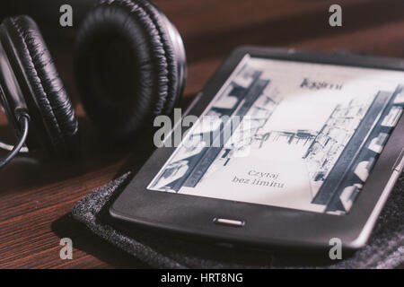 Paar Kopfhörer und open Ebook-Reader auf dem Schreibtisch Stockfoto