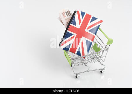 Union Jack Portemonnaie / Geldbörse mit £ 10 Banknoten in einem Spielzeug Einkaufswagen. Metapher für Großbritannien die Ausgaben der Verbraucher, Wirtschaft und Einzelhandel / High Street sales Stockfoto