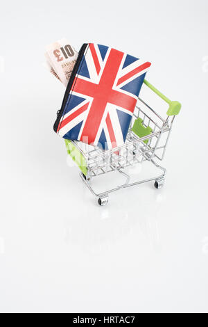 Union Jack Portemonnaie / Geldbörse mit £ 10 Banknoten in einem Spielzeug Einkaufswagen. Metapher für Großbritannien die Ausgaben der Verbraucher, Wirtschaft und Einzelhandel / High Street sales Stockfoto