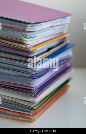 Verschiedene bunte Ordner mit Dokumenten gestapelt in einem Haufen auf dem Tisch. Close-up Stockfoto