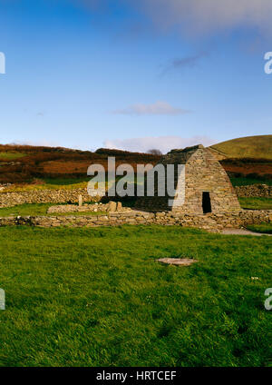 Gallarus bootsförmig Oratorium, Dingle, County Kerry, mit einer frühchristlichen eingeschrieben Stein steht auf einem rechteckigen Steinen (Leacht) daneben. Stockfoto