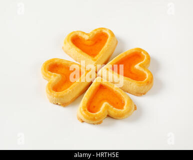 herzförmige Kekse mit Marmelade füllen auf weißem Hintergrund Stockfoto