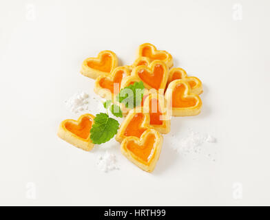 herzförmige Kekse mit Marmelade füllen auf weißem Hintergrund Stockfoto