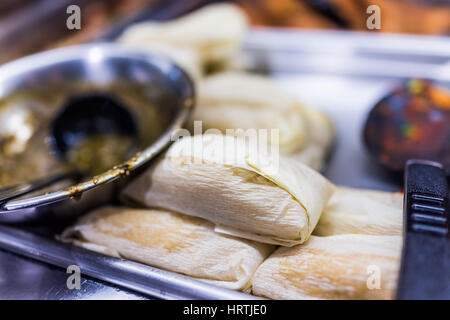 Tamales eingehülltes Maiskolben mit Sauce auf der Seite Stockfoto