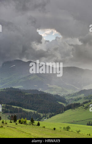 Gewitterwolken über die Berge und grüne Wiesen. Stockfoto