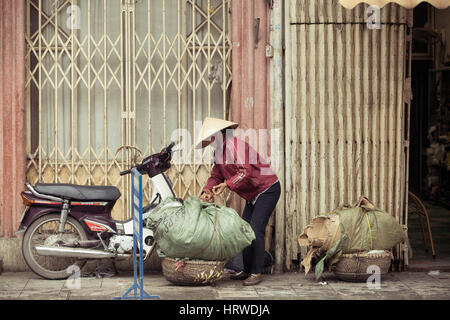 Hanoi, Vietnam - 3 März: Frauen Verpackung Körbe mit Pappe auf der Straße von Hanoi, 3. März 2014. Stockfoto