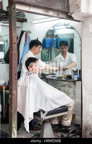 Hanoi, Vietnam - 25. April 2014: Friseur, Haarschnitt auf der Straße der Altstadt, Hanoi, Vietnam. Stockfoto