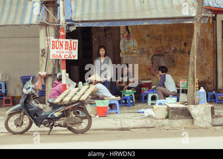 Hanoi, Vietnam - 2. März 2014: Einheimische Essen, sitzen auf Plastikstühlen an das traditionelle Straßencafé. Stockfoto