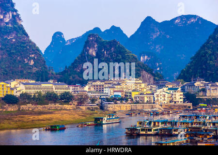 Blick auf Resort Stadt Guilin in Zentralchina mit vielen weißen Gebäuden Boot Peer Fluss und Karstberge auf Hintergrund Stockfoto