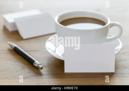 Leere Visitenkarten, Kugelschreiber und Tasse Kaffee am Tisch aus Holz. Corporate stationär branding Mock up. Stockfoto