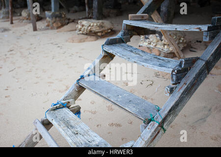 Der alte wackelige Holztreppe führt zum Sandstrand vor dem Hintergrund des Hundes wird gedruckt Stockfoto