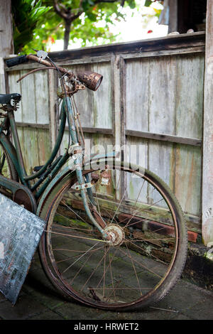 Alte Vintage gebrochen rostigen Fahrrad mit einer Laterne stehen auf der Straße im Dorf mit einer Reifenpanne Stockfoto