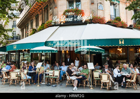 Französisches Restaurant, Abendessen unter freiem Himmel, Blick von außen auf das berühmte Les Deux Magots Café, mit Gästen, die an Tischen auf dem Bürgersteig sitzen, Paris, Frankreich. Stockfoto