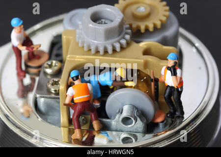Selektiven Fokus von Miniatur-Ingenieur und Arbeitskraft fixiert und Spieluhr und Nutzung für die betriebswirtschaftlichen Hintergrund zu reparieren. Stockfoto