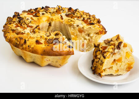 Quark-Kuchen mit Nüssen und getrockneten Aprikosen auf weißem Hintergrund. Studio Photo Stockfoto