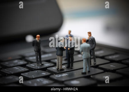 Selektiven Fokus Miniatur Geschäftsmann Handshake über Investitionen der Unternehmen auf die Tastatur Hintergrund als Verpflichtung und Vereinbarung Konzept. Stockfoto