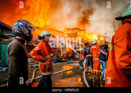 Ein Feuerunfall breitet sich aus und verbrennt Hunderte von Häusern in einer dichten Nachbarschaft in Jakarta, Indonesien. Stockfoto