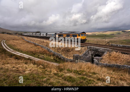 Class 66 Lokomotive vorbei Selside, schleppen einen Stein Zug von Arcow Steinbruch, Helwith Brücke, Ribblesdale, Yorkshire Dales National Park, UK Stockfoto