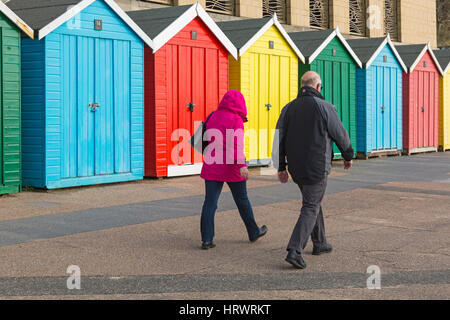 Boscombe, Bournemouth, Dorset, UK. 4. März 2017. UK-Wetter: sehr schön sonnig, aber windig, Tag an Stränden von Bournemouth, als Besucher gehen ans Meer, das Beste aus der Sonne zu machen. Paar genießen Sie einen Spaziergang entlang der Strandpromenade vorbei an bunten Strandhäuschen auf Boscombe Promenade Credit: Carolyn Jenkins/Alamy Live News Stockfoto