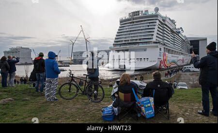 Die neue 334 Meter langen Kreuzfahrtschiff "Norwegian Freude" verlassen den überdachten Bau der Meyer Werft in Papenburg, Deutschland, 4. März 2017 andocken. Das riesige Schiff soll un fixiert und zum Pier Ausrüstung genommen werden. "Norwegische Freude" ist das größte Schiff, das jemals auf der Meyer Werft gebaut und die weltweit viertgrößte Passagierschiff. Am Ende des März wird der Neubau für die US-Reederei "Norwegian Cruise Line" auf der schmalen EMS zur Nordsee übertragen. Foto: Ingo Wagner/dpa Stockfoto