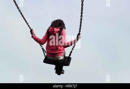 BERECHTIGUNG ERTEILT WIRD. Ein junges Mädchen spielt auf Schaukel in einem Park in der Nähe von Ashford, Kent. Stockfoto