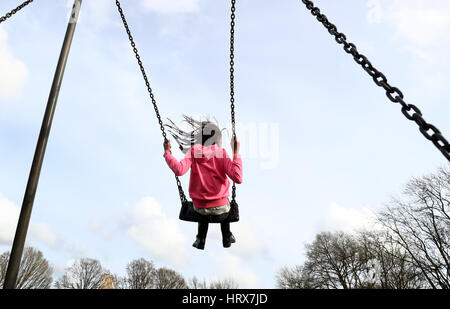 BERECHTIGUNG ERTEILT WIRD. Ein junges Mädchen spielt auf Schaukel in einem Park in der Nähe von Ashford, Kent. Stockfoto