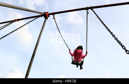 BERECHTIGUNG ERTEILT WIRD. Ein junges Mädchen spielt auf Schaukel in einem Park in der Nähe von Ashford, Kent. Stockfoto