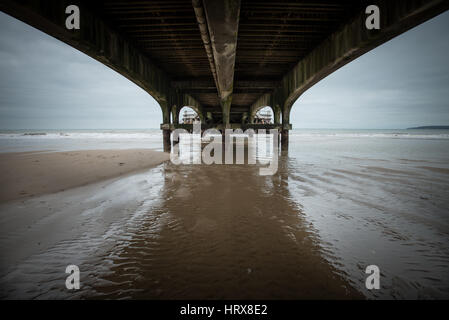 Beton Bögen unter Bournemouth Pier bei Ebbe an einem bewölkten Winter Tag in Dorset, England, UK. Stockfoto