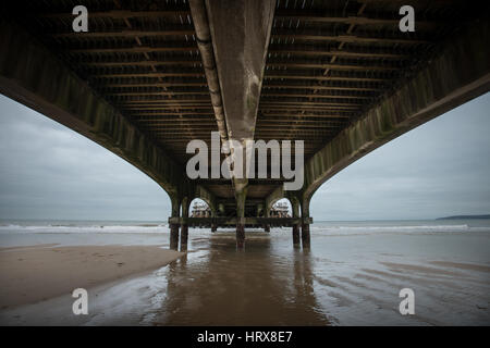 Beton Bögen unter Bournemouth Pier bei Ebbe an einem bewölkten Winter Tag in Dorset, England, UK. Stockfoto