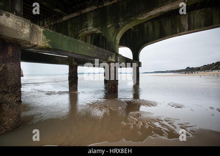 Beton Bögen unter Bournemouth Pier bei Ebbe an einem bewölkten Winter Tag in Dorset, England, UK. Stockfoto