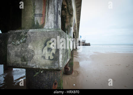 Graffiti auf einem Stein Spalte unter Bournemouth Pier an einem Wintertag in Dorset, Großbritannien. Stockfoto